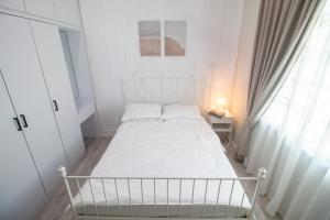 马兰Romi Homestay Wakaf Tapai的白色的卧室设有白色的床和窗户。