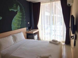 Ban Khlong HaengGO INN Krabi Aonang Beach โกอินน์ กระบี่ อ่าวนาง的卧室配有一张挂着龙画的墙壁床。