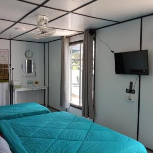 瓜拉丁加奴Rimbun Bayu Homestay的客房设有两张床、一台电视和一扇窗户。