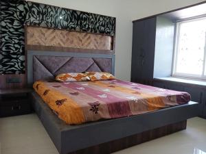 德奥加尔Vaidhya homes的一间卧室配有一张大床和木制床头板