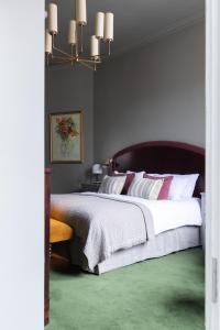 林肯林肯白鹿酒店的一间卧室配有一张大床,铺有绿色地毯