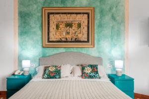 奥尔比亚斯特法尼亚海滩边酒店的一间卧室配有一张大床和两张蓝色的桌子