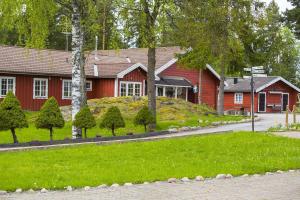 MarielundOdalgården Hotell, Kurs & Konferens的前面有草地的红色房子