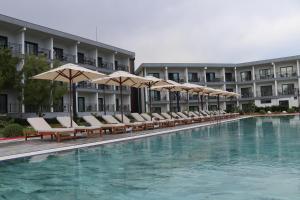 YesilovacıkTOROS DELUXE RESORT HOTEL的酒店游泳池设有椅子和遮阳伞