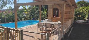 勒马兰Noukatchimbe Bungalow avec piscine partagée pour 2 à 4 personnes的池畔甲板配有桌椅