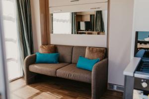 波特兰Studio Pod 2的客厅里配有带两个蓝色枕头的棕色沙发