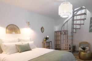 莫雷卢安河Lavilla dorée的卧室设有白色的床和螺旋楼梯。