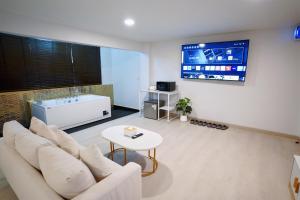 南邦The Space Hotel Lampang的客厅配有白色沙发和电视