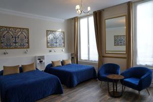 巴黎蒙庞西耶酒店的一间设有两张床和一张桌子及椅子的房间