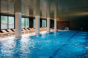 亚列姆切MORVA Premium Spa Resort的一个配有椅子的大型游泳池,一个站在里面的人