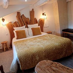 LE GRAND LOGIS, chambre Santorin avec spa privatif的一间卧室配有一张大床和木制床头板