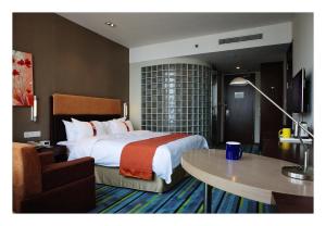 威海威海高新智选假日酒店的酒店客房设有一张大床和一张桌子。