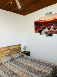 伊科德洛斯维诺斯Pintadera house Caracola的一间卧室设有两张床,墙上挂着一幅画