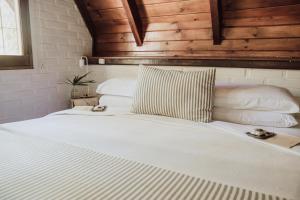 伊瓜苏港Overo Lodge & Selva的卧室配有带枕头的白色床