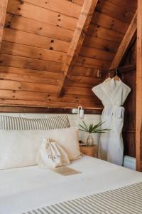 伊瓜苏港Overo Lodge & Selva的卧室配有白色的床铺和木制天花板