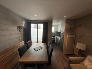 La Plagne TarentaiseBELLE PLAGNE - Appartement 6 personnes sur les pistes的厨房以及带木桌和椅子的用餐室。