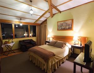 库斯科埃尔彪马酒店的一间卧室配有一张床、一把椅子和窗户。