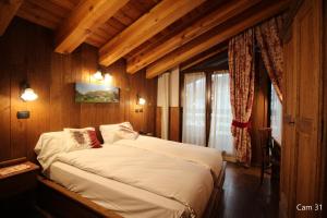 布勒伊-切尔维尼亚美奈特酒店的卧室配有一张床铺,位于带木墙的房间内