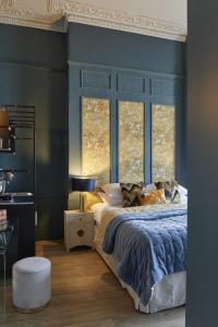 切尔滕纳姆81 Promenade Studios的一间卧室配有一张蓝色墙壁和窗户的床