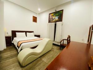 绥和市Jen Hotel的酒店客房配有一张床铺和一张桌子。
