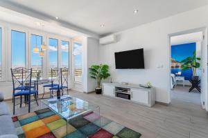 阿利坎特Sky Suites Alicante的客厅配有电视和桌椅