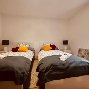 CierpAMPLE Conciergerie的一间卧室配有两张带黄色枕头的床