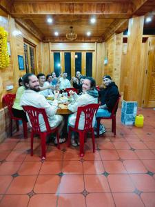 萨帕Hmong Wooden Home的一群人坐在餐馆的桌子旁