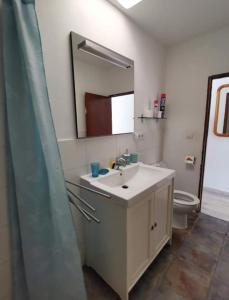 卡门港Bungalow Primavera的一间带水槽、卫生间和镜子的浴室