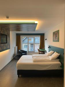 韦姆RAVeL Hotel Cyrano的一间卧室设有一张大床和一个窗户。