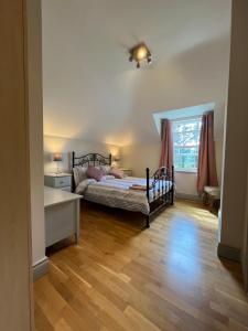 金塞尔clover cottage的一间卧室配有一张床、一张书桌和一个窗户。