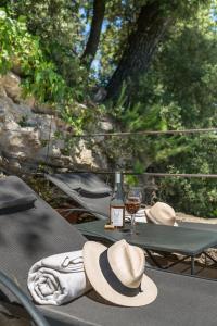 奥佩德Domaine Les Roullets的一张带帽子和一瓶葡萄酒的桌子