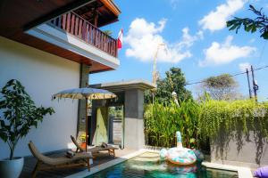塞米亚克Tropical Beach House Bali的一座带游泳池和遮阳伞的房子