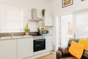 卡尔迪科特Superb Tiny Home in Caldicot with Parking的厨房配有水槽和炉灶 顶部烤箱