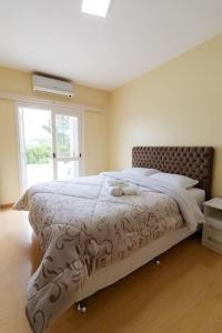 本图贡萨尔维斯Casa para 6 pessoas的卧室配有一张带白色棉被的床和窗户。
