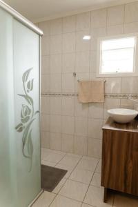 本图贡萨尔维斯Casa para 6 pessoas的一间带水槽和玻璃淋浴的浴室