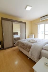 本图贡萨尔维斯Casa para 6 pessoas的一间卧室设有一张大床和一个大镜子