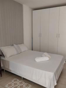 萨尔瓦多APARTAMENTO ITAIGARA的白色卧室配有一张带白色橱柜的床