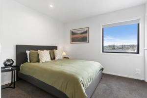 奥克兰Contemporary Urban Retreat的一间卧室设有一张大床和一个窗户。