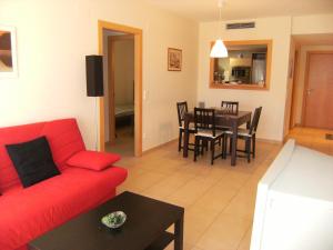 安普里亚斯Apartamentos Athenea的客厅配有红色的沙发和桌子