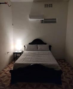 马里基塔SAN SENDERISMO ROOM的一间卧室配有一张床和一个带灯的床头柜