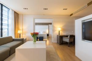 海牙Leonardo Royal Hotel Den Haag Promenade的客厅配有沙发和桌子