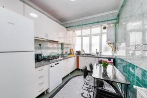 伊斯坦布尔Nil Denis Palace的厨房配有白色橱柜和桌椅