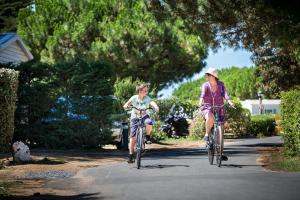 拉弗洛特白杨树露营地的骑着自行车沿着街道的男孩和女孩