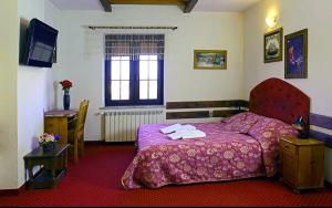 Rymanów贾斯韦德罗尼兹克旅馆的一间卧室配有一张紫色床和毛巾