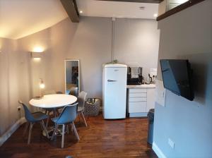 伦敦Self-contained Studio in Central London property Unit 4的厨房配有桌子和白色冰箱。