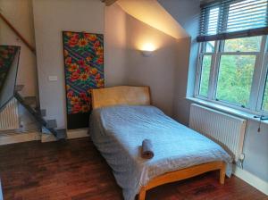 伦敦Self-contained Studio in Central London property Unit 4的小房间,配有一张带蓝色毯子的床