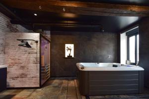埃普索瓦日La Forge By CV - Jacuzzi, Sauna, plat repas et petit déjeuner的带浴缸和盥洗盆的浴室
