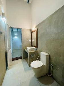 锡吉里亚RHO Sigiriya Lake Edge Retreat & Spa的浴室配有卫生间、盥洗盆和淋浴。