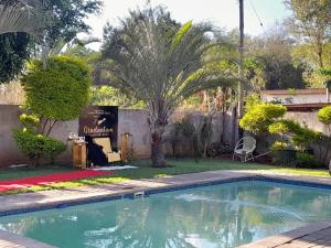 哈博罗内Villa54的棕榈树庭院中的游泳池