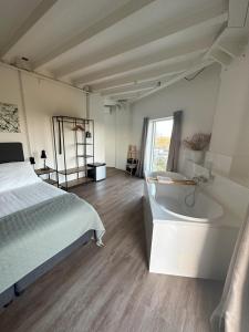 多德雷赫特德沃特托伦酒店的卧室配有床、浴缸和窗户。
